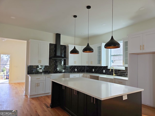 721 Cascade Ave SW, Atlanta, GA 30310 - kitchen featuring wall chimney exhaust hood, healthy amount of natural light, backsplash, and white cabinets