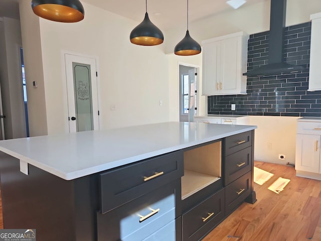 721 Cascade Ave SW, Atlanta, GA 30310 - kitchen featuring white cabinetry, wall chimney range hood, decorative backsplash, light wood-style floors, and light countertops