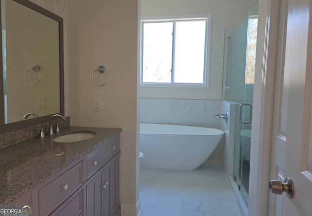 721 Cascade Ave SW, Atlanta, GA 30310 - bathroom featuring marble finish floors, plenty of natural light, vanity, and a soaking tub