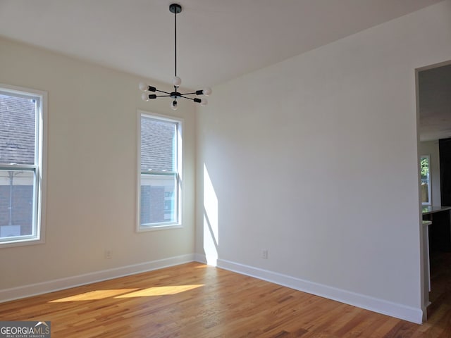 721 Cascade Ave SW, Atlanta, GA 30310 - spare room featuring light wood-type flooring and a chandelier