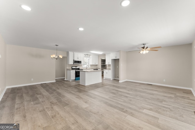 unfurnished living room featuring light wood finished floors and baseboards