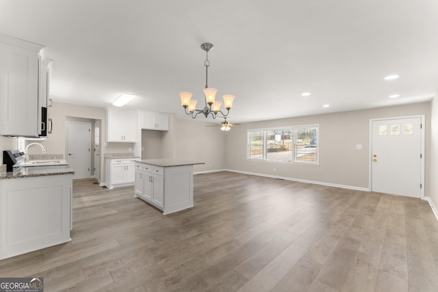 kitchen featuring a notable chandelier, light wood-style floors, white cabinetry, and a kitchen island