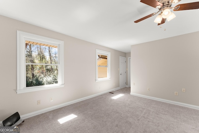 carpeted empty room featuring ceiling fan, baseboards, and visible vents