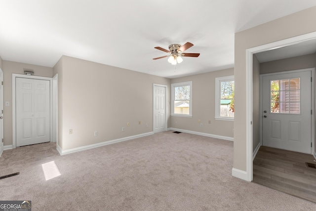 interior space with visible vents, baseboards, and ceiling fan