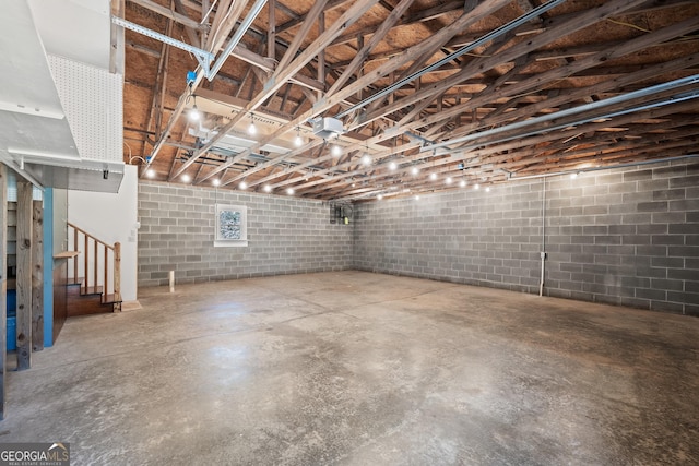 basement with concrete block wall and stairway