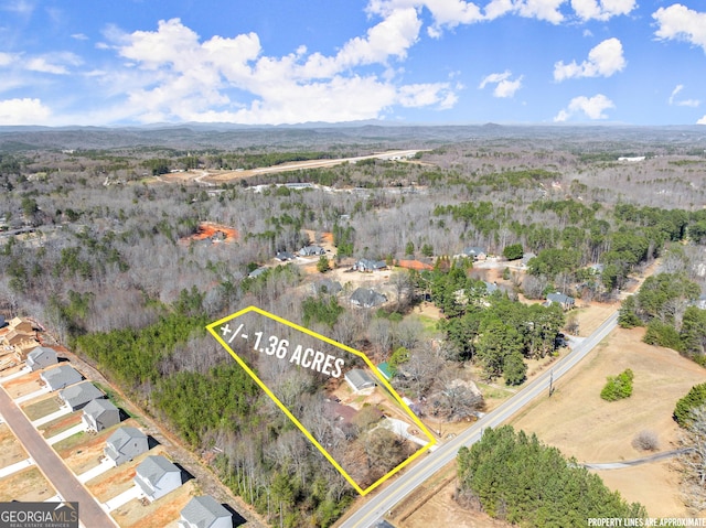 drone / aerial view with a wooded view