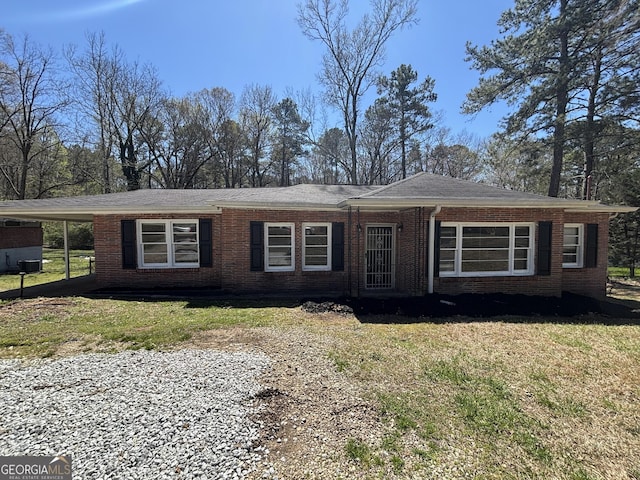 view of property exterior featuring brick siding, a lawn, and a carport