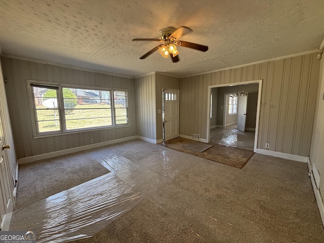 entryway featuring carpet, ornamental molding, baseboards, a textured ceiling, and ceiling fan