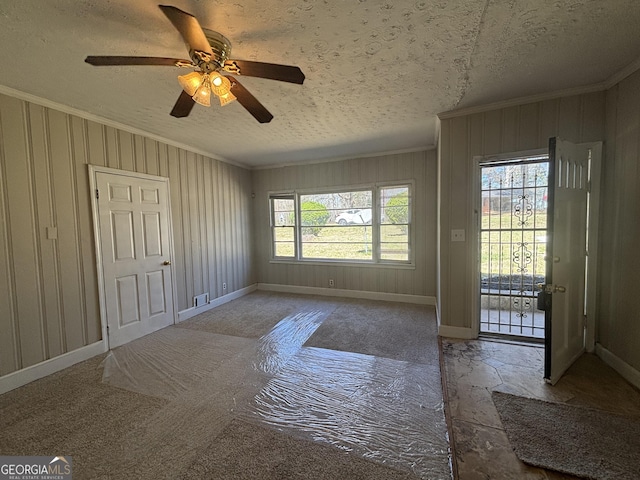 interior space with a ceiling fan, baseboards, crown molding, and a textured ceiling