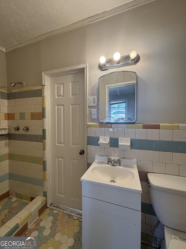 bathroom featuring toilet, a stall shower, tile patterned flooring, vanity, and ornamental molding