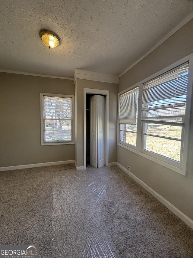 unfurnished bedroom featuring multiple windows, a textured ceiling, a closet, and crown molding