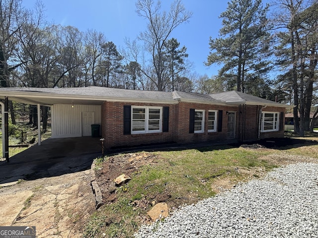 ranch-style house featuring brick siding, driveway, and an attached carport