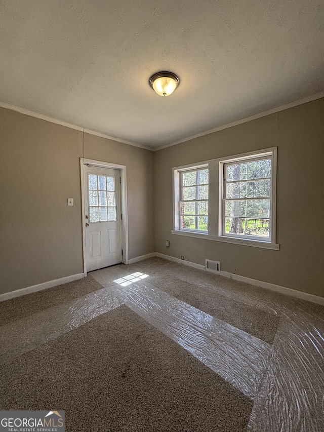 interior space featuring baseboards, crown molding, and visible vents