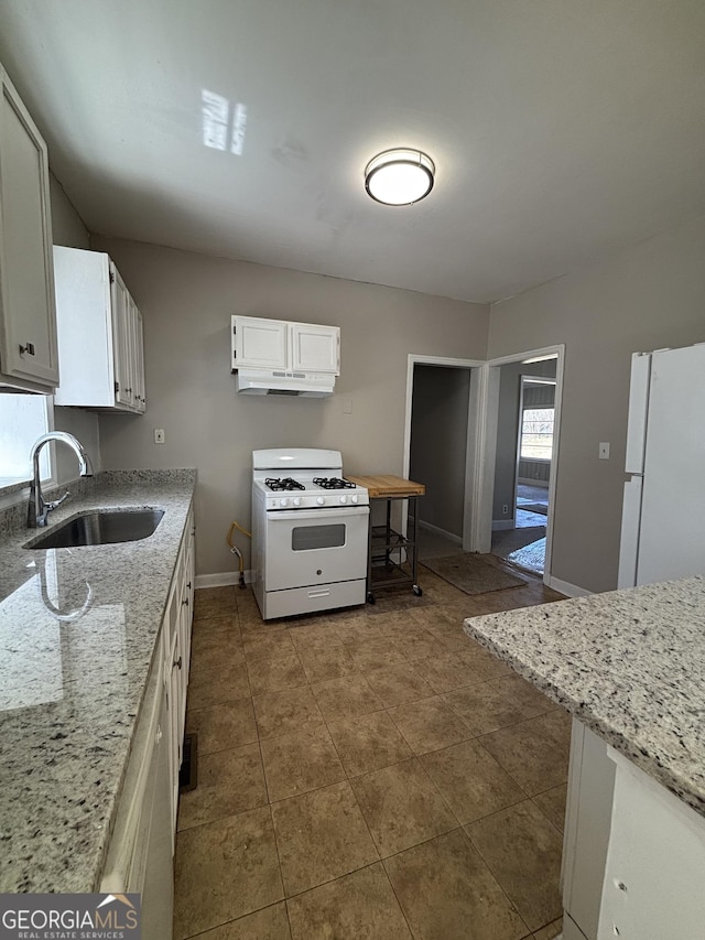 kitchen featuring a sink, baseboards, white cabinetry, white appliances, and under cabinet range hood