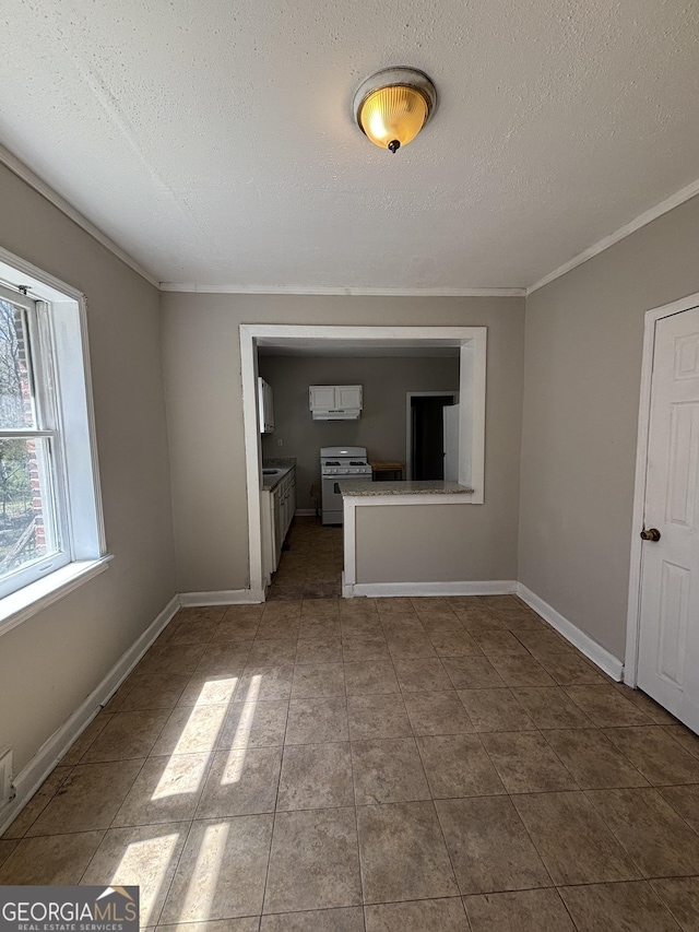 unfurnished living room featuring baseboards, tile patterned floors, and a textured ceiling