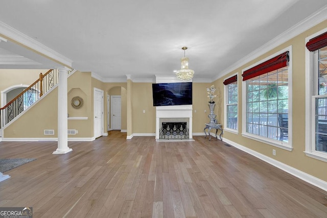 1621 Telfair Chase Way, Lawrenceville, GA 30043 - unfurnished living room featuring arched walkways, crown molding, wood finished floors, a fireplace with flush hearth, and stairs