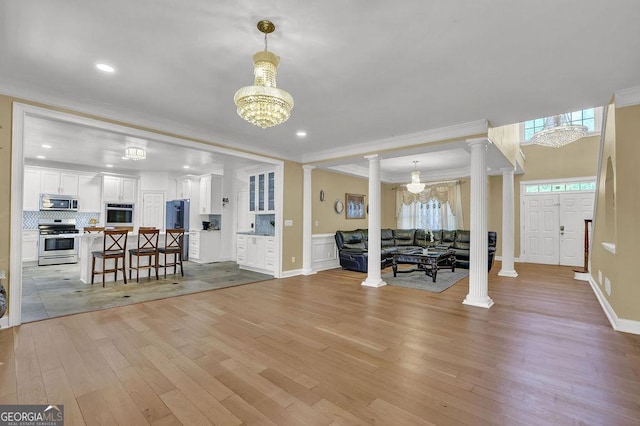 1621 Telfair Chase Way, Lawrenceville, GA 30043 - living room featuring crown molding, ornate columns, an inviting chandelier, and light wood-style floors
