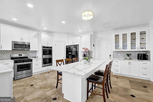 1621 Telfair Chase Way, Lawrenceville, GA 30043 - kitchen with decorative backsplash, white cabinetry, a kitchen breakfast bar, and stainless steel appliances