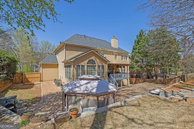 1621 Telfair Chase Way, Lawrenceville, GA 30043 - back of property featuring a chimney, a fenced backyard, cooling unit, a patio, and a gate