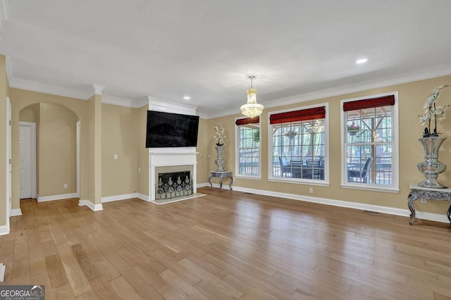 1621 Telfair Chase Way, Lawrenceville, GA 30043 - unfurnished living room with arched walkways, light wood-style flooring, ornamental molding, and a healthy amount of sunlight