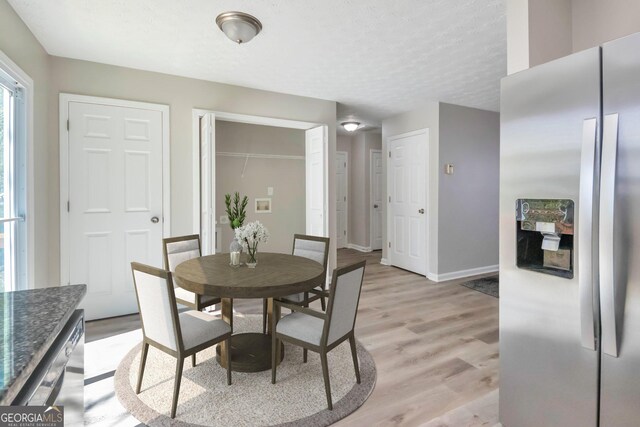 344 Springbottom Ct, Lawrenceville, GA 30046 - dining space with baseboards, a textured ceiling, and light wood finished floors