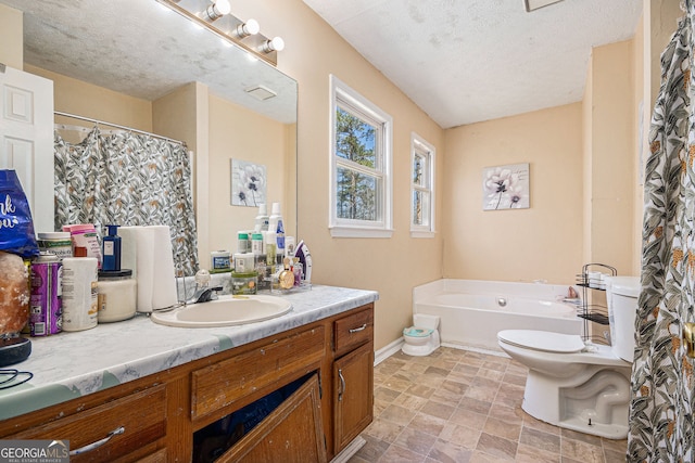 full bath featuring a textured ceiling, a garden tub, vanity, toilet, and baseboards