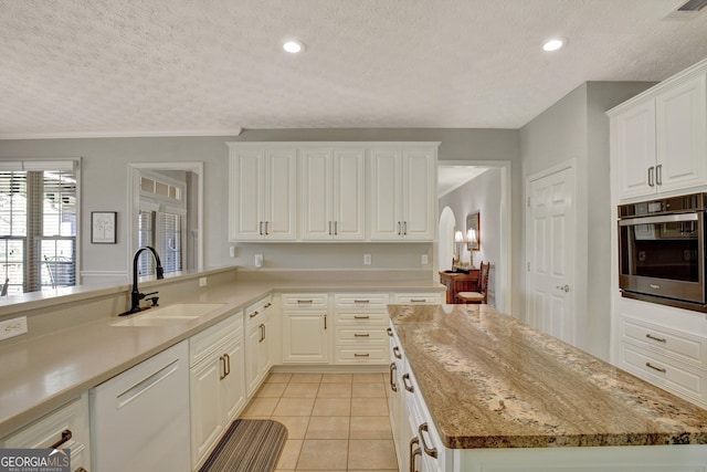 kitchen with light tile patterned floors, visible vents, oven, a sink, and dishwasher