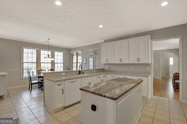 kitchen with a center island, a chandelier, white dishwasher, light tile patterned flooring, and a sink