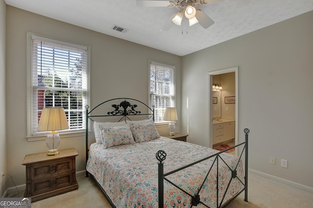 bedroom with a textured ceiling, carpet, visible vents, and baseboards
