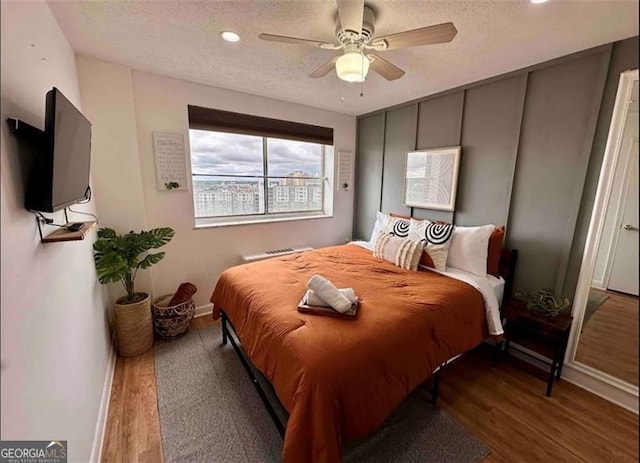 215 Piedmont Ave NE Unit 2205, Atlanta, GA 30308 - bedroom with a textured ceiling, baseboards, ceiling fan, and wood finished floors