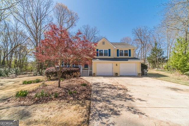 45 Somerset Ct, Covington, GA 30016 - view of front of house with a chimney, a porch, driveway, and an attached garage