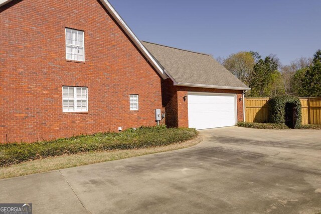 430 Brantley Rdg, Warner Robins, GA 31088 - view of side of property featuring brick siding, concrete driveway, an attached garage, and roof with shingles