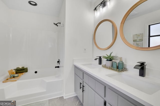 full bathroom featuring double vanity, a sink, marble finish floor, and bathtub / shower combination