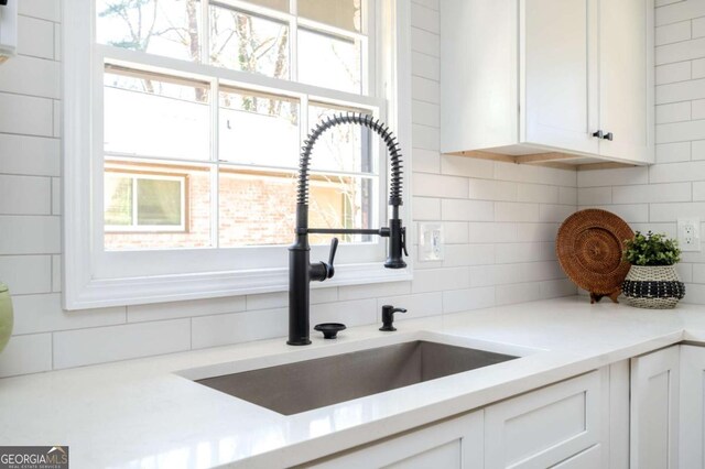 kitchen with a healthy amount of sunlight, white cabinetry, and a sink