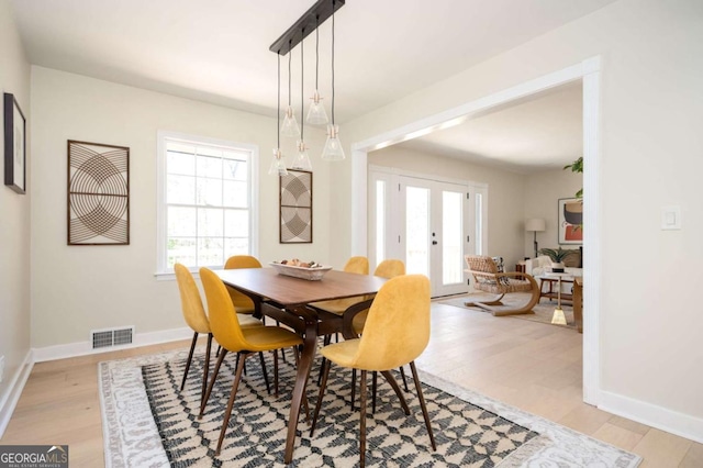 dining room featuring baseboards, visible vents, and light wood-type flooring