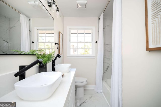 bathroom featuring a sink, marble finish floor, and a healthy amount of sunlight