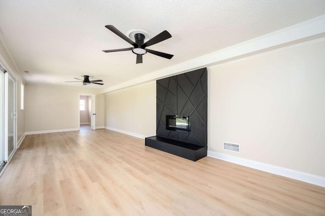 unfurnished living room with visible vents, a textured ceiling, light wood-type flooring, and ceiling fan