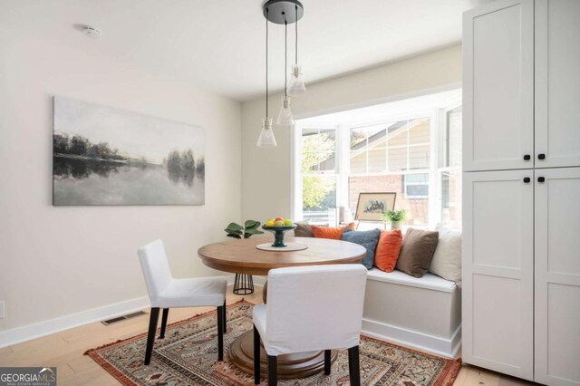 dining space featuring light wood-type flooring, baseboards, and visible vents
