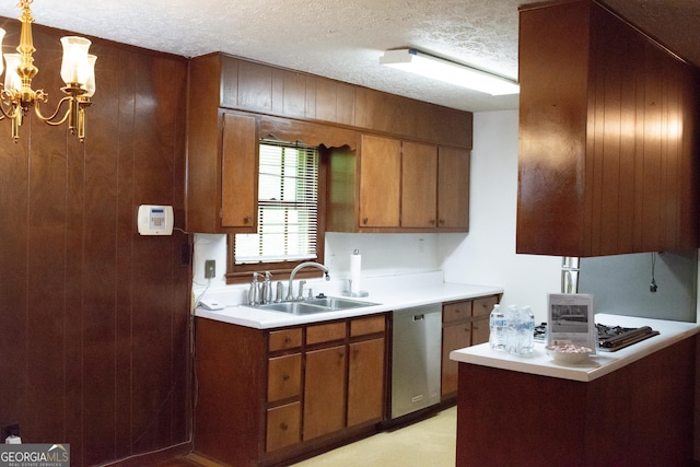 kitchen with stainless steel dishwasher, brown cabinets, a sink, and light countertops