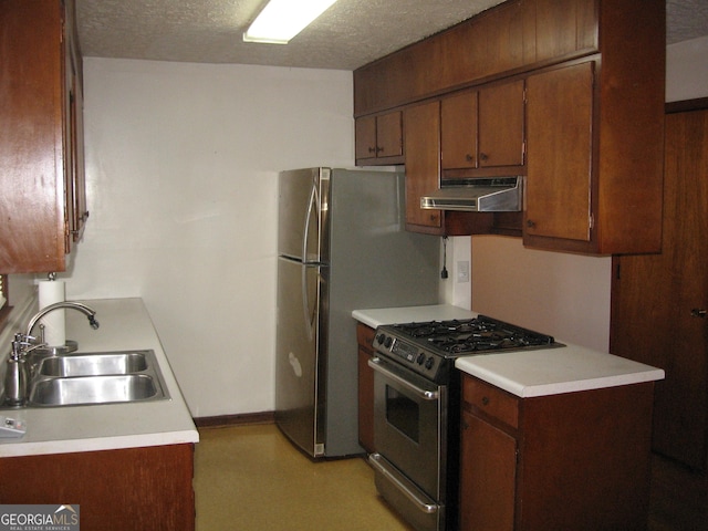 kitchen featuring light countertops, a sink, under cabinet range hood, and stainless steel appliances