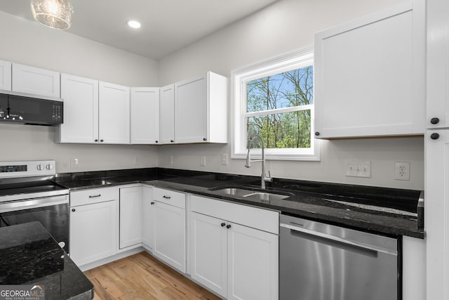 164 Colorado Ln, Clayton, GA 30525 - kitchen with appliances with stainless steel finishes, an inviting chandelier, a kitchen island, dark countertops, and light wood-style floors