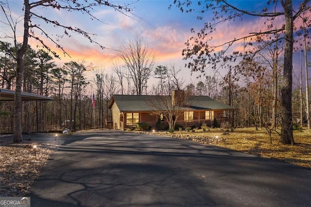 chalet / cabin with a carport and aphalt driveway