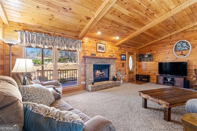 carpeted living area featuring wooden ceiling, wood walls, a stone fireplace, and vaulted ceiling with beams