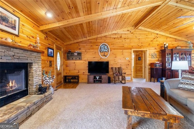 carpeted living area with wooden ceiling, wood walls, a fireplace, and vaulted ceiling with beams