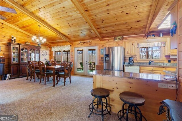 kitchen with light colored carpet, dishwasher, wooden walls, stainless steel fridge, and wood ceiling