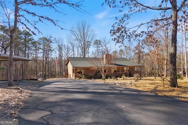 view of front facade with a porch, aphalt driveway, and a carport