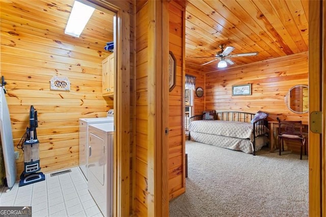 laundry area featuring cabinet space, washer and clothes dryer, wooden walls, and wood ceiling