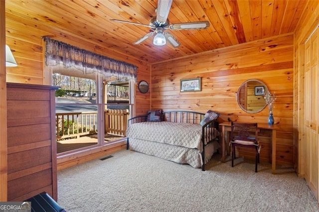 bedroom with wooden walls, wood ceiling, carpet floors, and visible vents