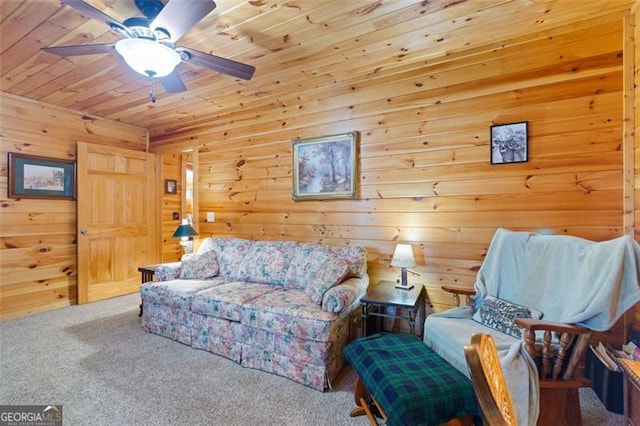 living area featuring ceiling fan, wood walls, carpet, and wood ceiling