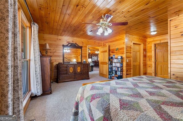 carpeted bedroom featuring wooden walls and wood ceiling